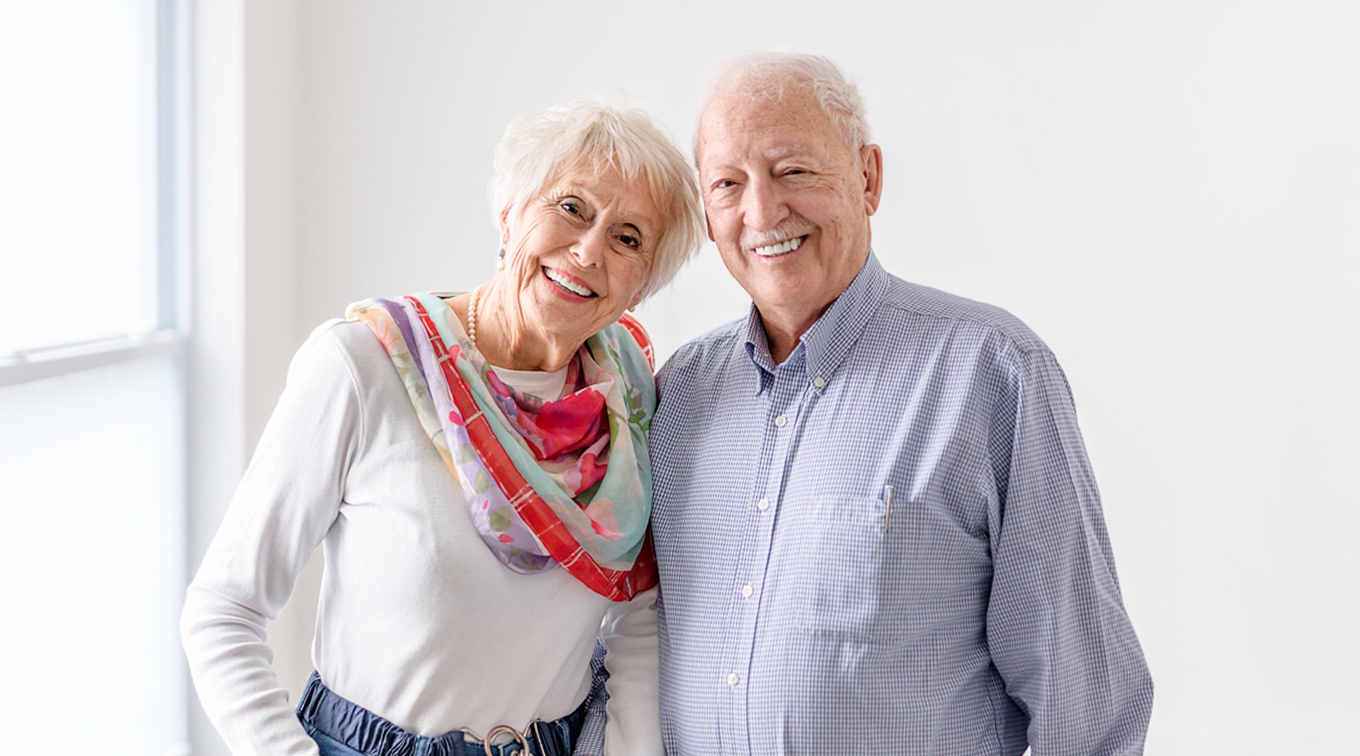 senior retired couple having great moment together close to a window